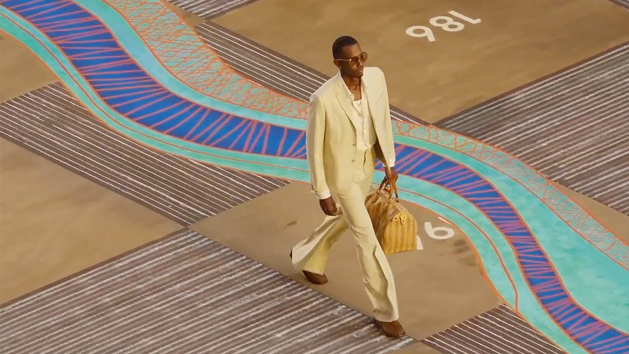 Model in a cream suit walks the Louis Vuitton Men’s Spring-Summer 2026 runway, showcasing Pharrell Williams’s modern luxury menswear vision.
